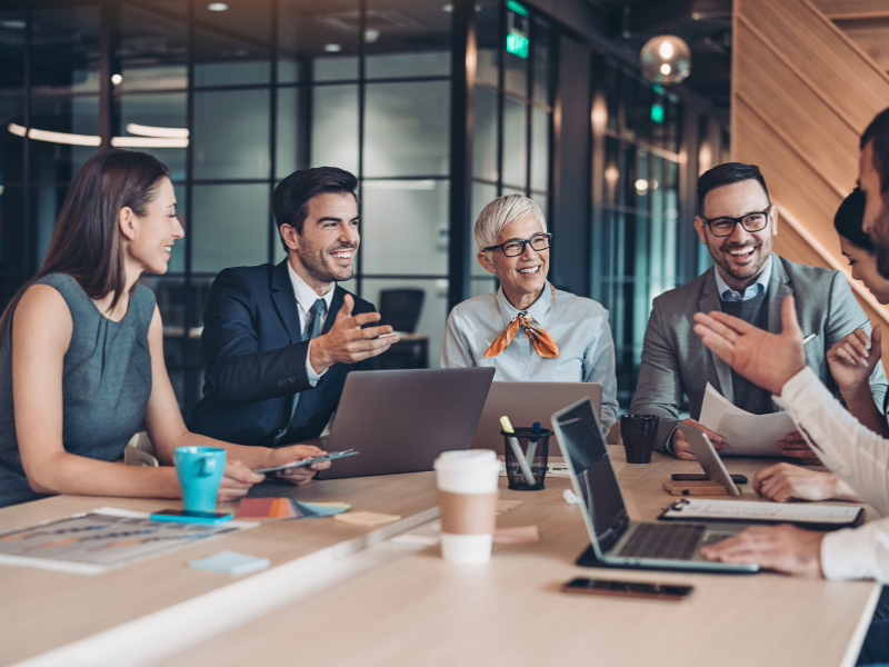 Group sitting at a desk talking at a business meeting