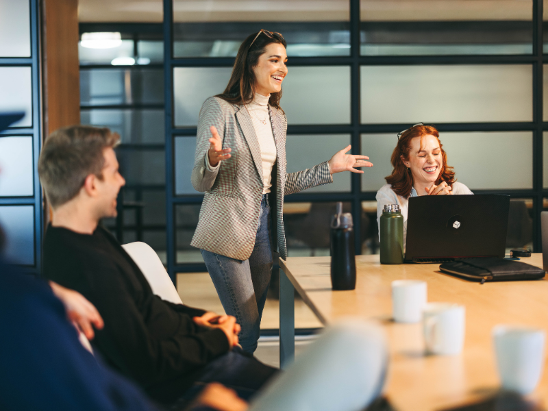 woman standing and presenting in front of team