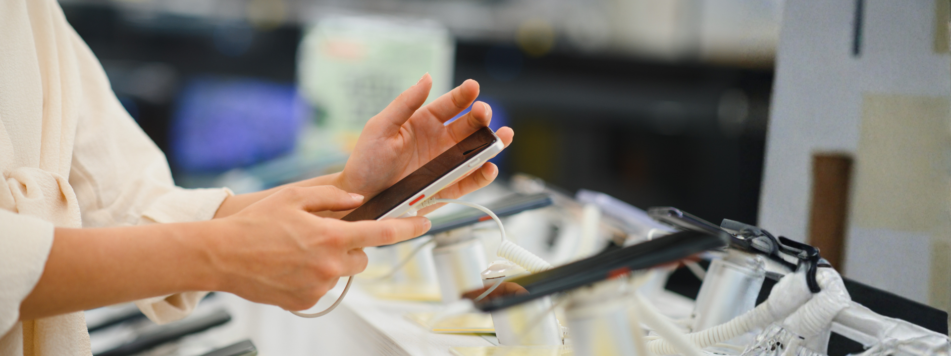 A woman choosing a smartphone in an electronics store