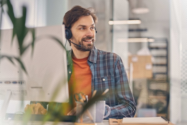 Contact Center Support Man Typing on Keyboard with Headset