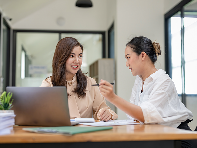 Two business woman talking to each other