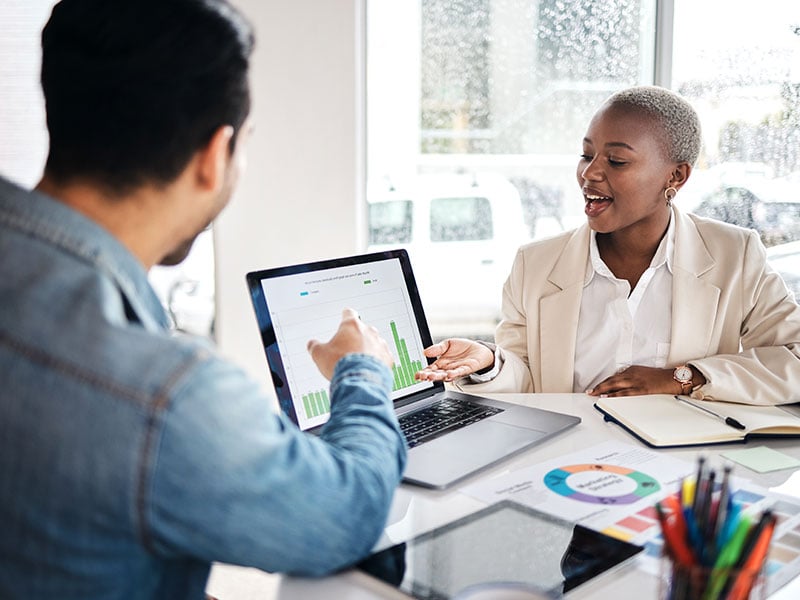 An employee presenting an analytics graph in a meeting