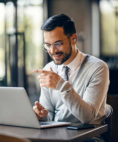 Employee participating in a virutal meeting at his laptop