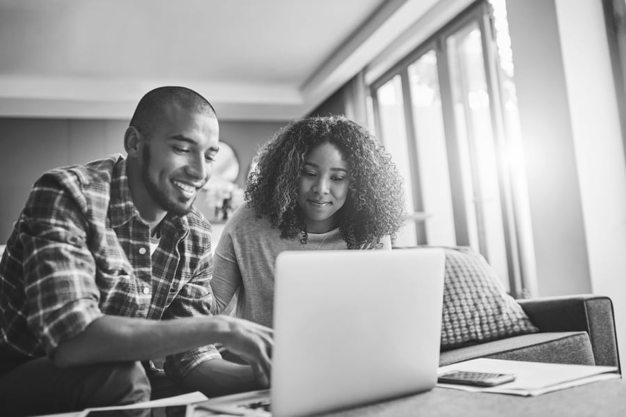 Young couple sitting comfortably on the couch and using a laptop