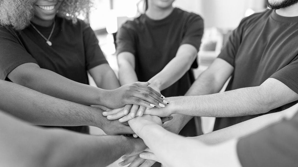 Group of people holding hands in solidarity.