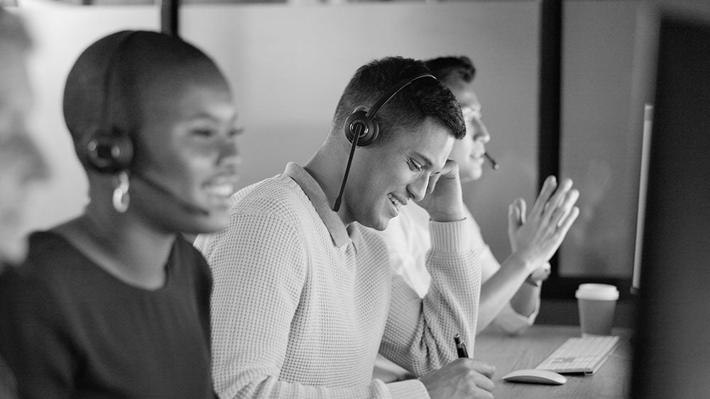 A diverse customer support team engaging positively with clients, reflecting the uplifted agent experience and service culture shaped by the consulting engagement.