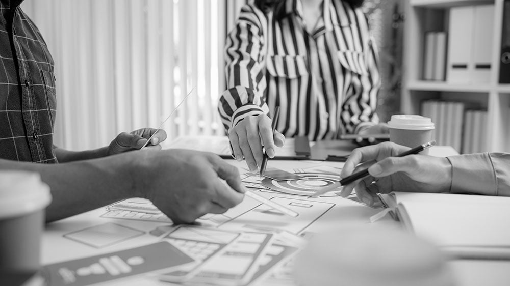 A team is collaborating on UX design at the workplace.
