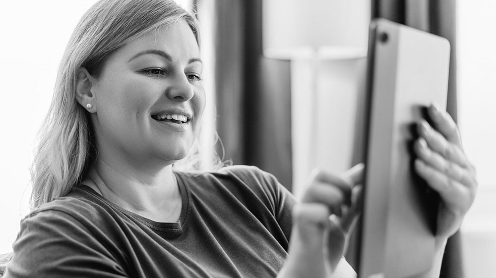 A satisfied customer enjoying a seamless digital experience on her tablet at home.