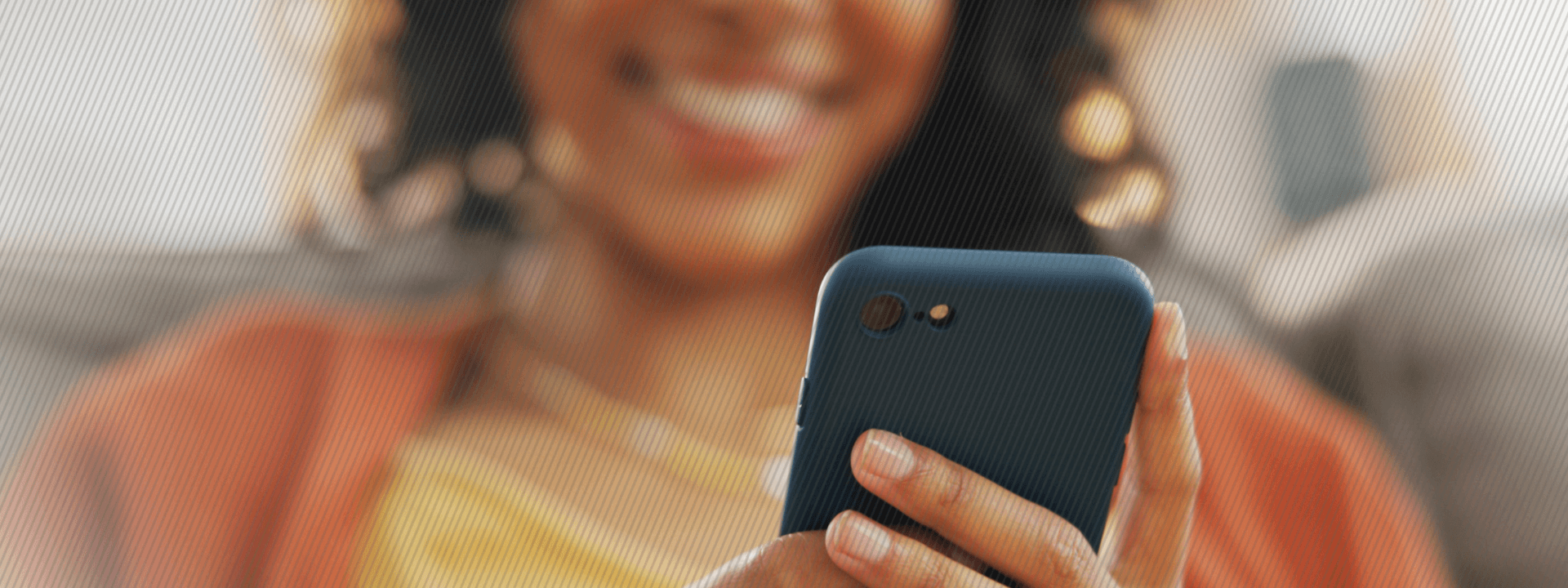 woman sitting on the couching and using her phone