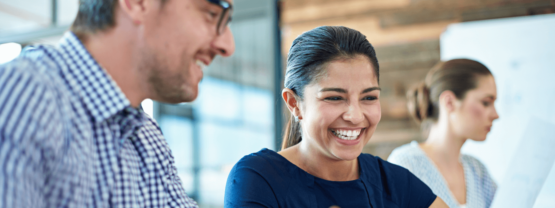 Two employees laughing and collaborating on a project