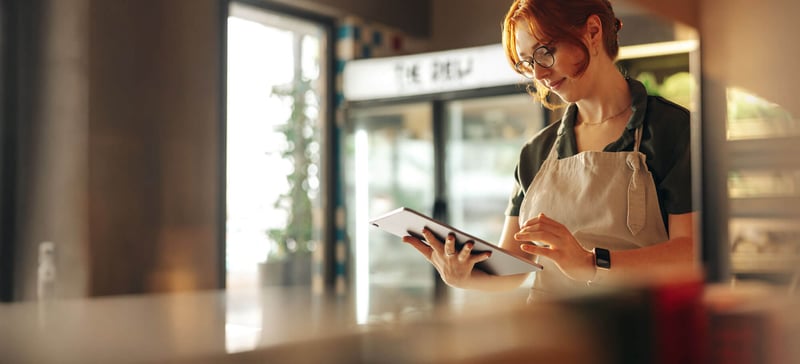 A female employee using a tablet in a grocery store