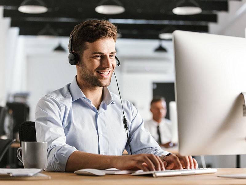 Call center employee wearing a headset at a desk