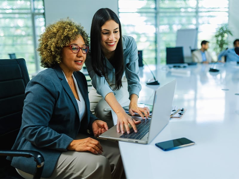 Businesswoman working together on laptops and tablets in office