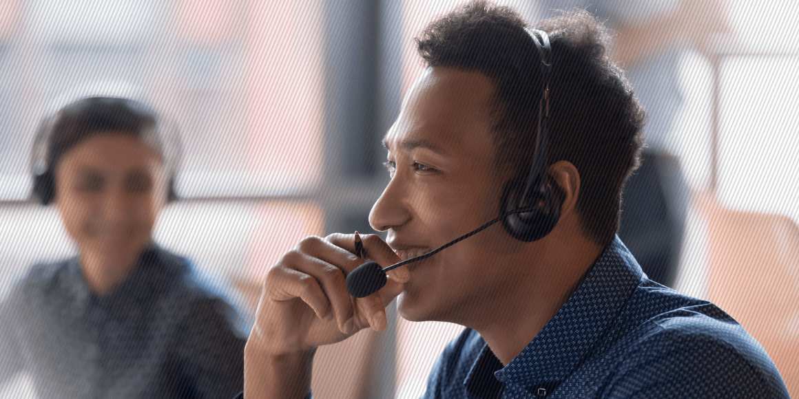 Featured image: Smiling contact center agent wearing a headset as he answers a customer inquiry - Read full post: Overcoming the Blind Spots in a Quality Assurance Practice