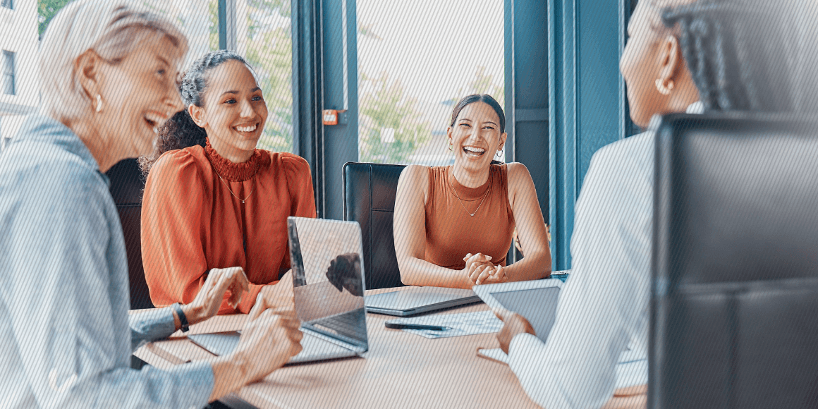 Featured image: A group of employees laughing during a meeting - Read full post: Creating A Sense Of Belonging For Employee Retention