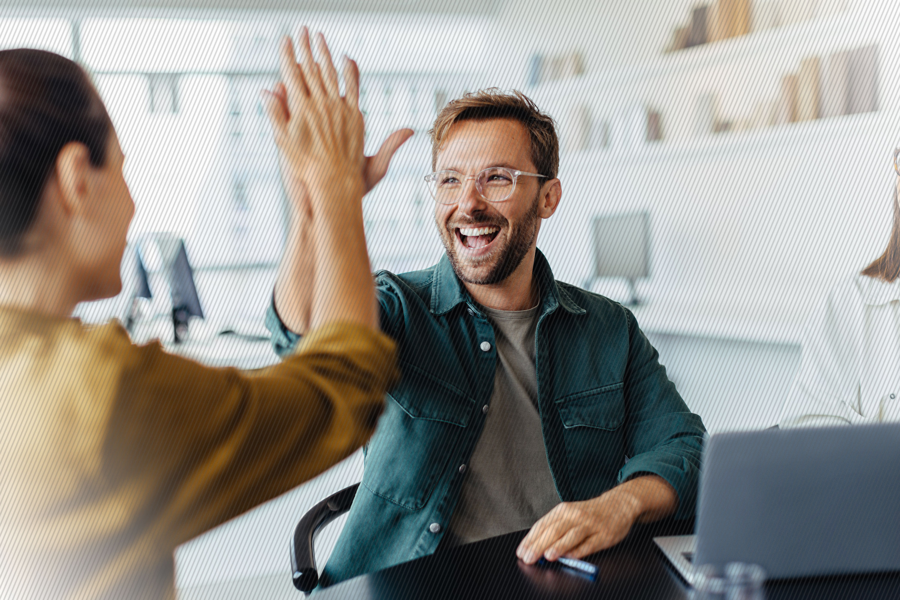 Featured image: Two happy employees high-fiving in the office - Read full post: Create Crazy Loyal Customers with Andrew Reise